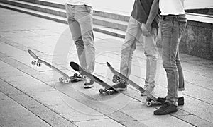 Group of skateboarders are standing near their boards