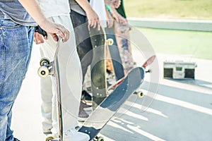 Group of skaters friends in urban contest with skateboards in their hands - Young men training with boards in skate park - Extreme photo