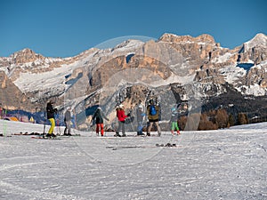 Group of Skiers, adults, teenagers and children ready to face a Descent on the Ski Slope, in the background the Beautiful Italian