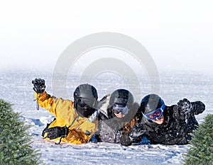 A group of skiers lie on the snow and wave .Winter background with copy space.