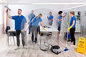 Group Of Skilled Janitors Cleaning Office