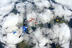 Skydivers are in the cloudy sky.
