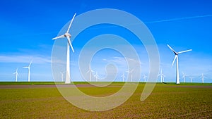 A group of sleek wind turbines stand tall in a vibrant field in Flevoland, windmill turbines on land