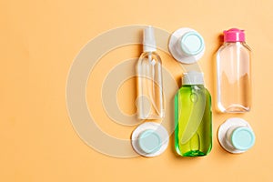 Group of small bottles for travelling on colored background. Copy space for your ideas. Flat lay composition of cosmetic products