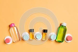 Group of small bottles for travelling on colored background. Copy space for your ideas. Flat lay composition of cosmetic products