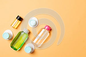 Group of small bottles for travelling on colored background. Copy space for your ideas. Flat lay composition of cosmetic products