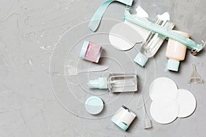 Group of small bottles for travelling on gray background. Copy space for your ideas. Flat lay composition of cosmetic products.