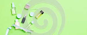 Group of small bottles for travelling on green background. Copy space for your ideas. Flat lay composition of cosmetic products.