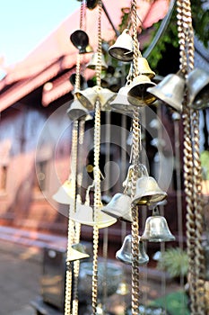 A group of small  bronze bells hanging from a chain