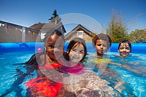 Group small kids friends in swimming pool together