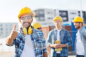 Group of smiling builders in hardhats outdoors