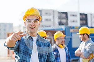 Group of smiling builders in hardhats outdoors