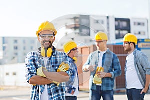 Group of smiling builders in hardhats outdoors