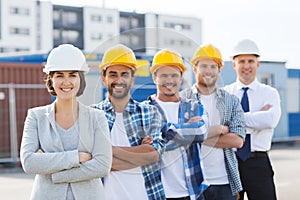 Group of smiling builders in hardhats outdoors