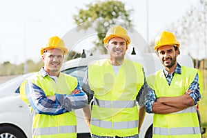 Group of smiling builders in hardhats outdoors