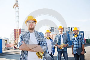 Group of smiling builders in hardhats outdoors