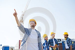 Group of smiling builders in hardhats outdoors