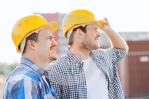 Group of smiling builders in hardhats outdoors