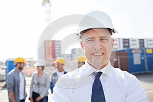 Group of smiling builders in hardhats outdoors