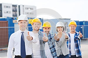 Group of smiling builders in hardhats outdoors