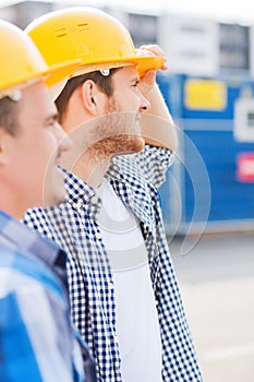 Group of smiling builders in hardhats outdoors