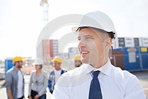 Group of smiling builders in hardhats outdoors