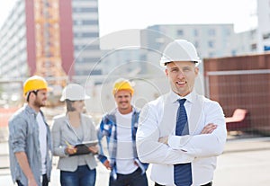 Group of smiling builders in hardhats outdoors