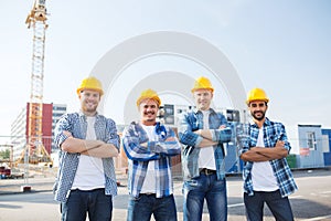 Group of smiling builders in hardhats outdoors