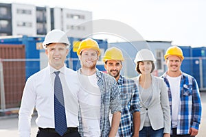 Group of smiling builders in hardhats outdoors