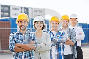 Group of smiling builders in hardhats outdoors