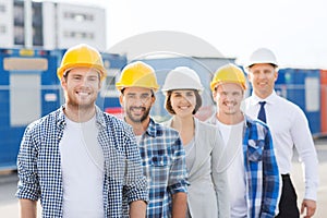 Group of smiling builders in hardhats outdoors