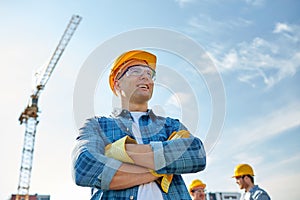 Group of smiling builders in hardhats outdoors