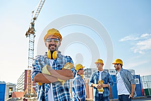 Group of smiling builders in hardhats outdoors