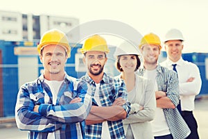 Group of smiling builders in hardhats outdoors