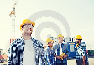 Group of smiling builders in hardhats outdoors