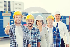 Group of smiling builders in hardhats outdoors