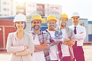 Group of smiling builders in hardhats outdoors