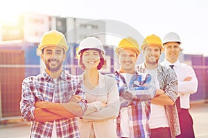 Group of smiling builders in hardhats outdoors