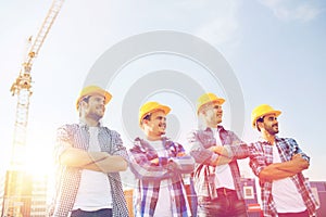 Group of smiling builders in hardhats outdoors