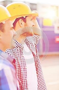 Group of smiling builders in hardhats outdoors