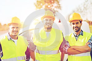 Group of smiling builders in hardhats outdoors