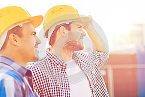 Group of smiling builders in hardhats outdoors