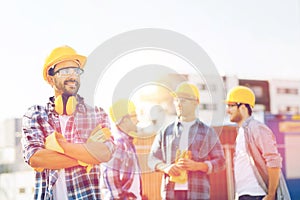 Group of smiling builders in hardhats outdoors