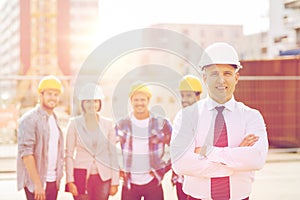 Group of smiling builders in hardhats outdoors