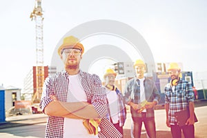 Group of smiling builders in hardhats outdoors