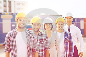 Group of smiling builders in hardhats outdoors