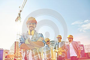 Group of smiling builders in hardhats outdoors