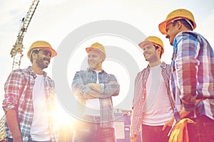 Group of smiling builders in hardhats outdoors