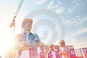 Group of smiling builders in hardhats outdoors