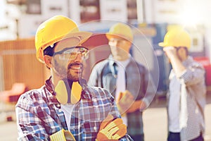 Group of smiling builders in hardhats outdoors photo